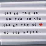 Paper tray with playful text phrases and a red heart, captured with shadows.